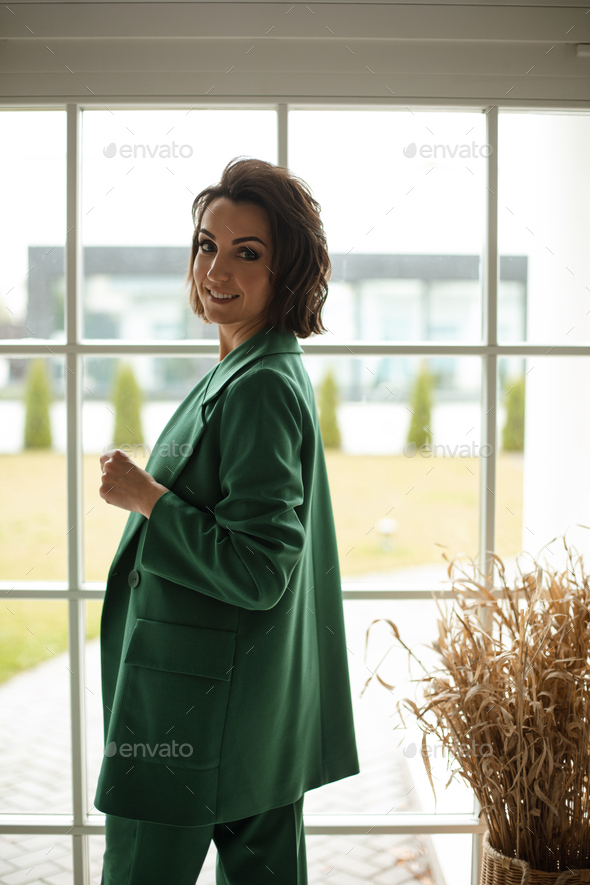 Cheerful smiling businesswoman in green jacket - Stock Photo - Images