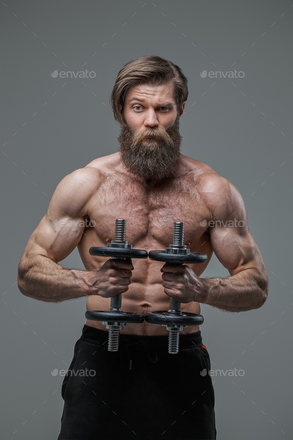 Athletic man with fashionable hairstyle and dumbells in studio Stock Photo  by fxquadro
