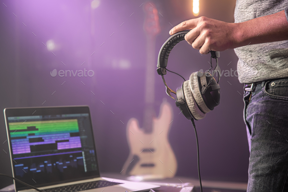 Studio audio headphones for recording sound in male hands on a blurred studio  background. Stock Photo by puhimec