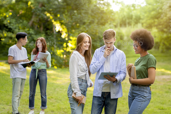 Multi-ethnic group of students spending time together outdoors at college campus