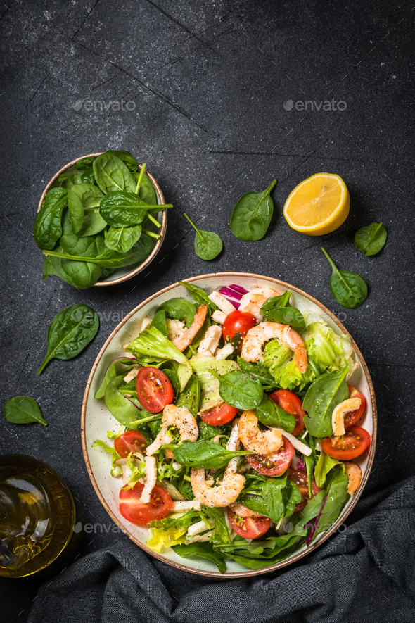 Shrimp salad with green leaves at stone table - Stock Photo - Images
