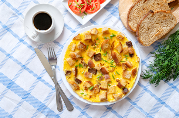 Omelet with pieces of toasted bread and a cup of coffee