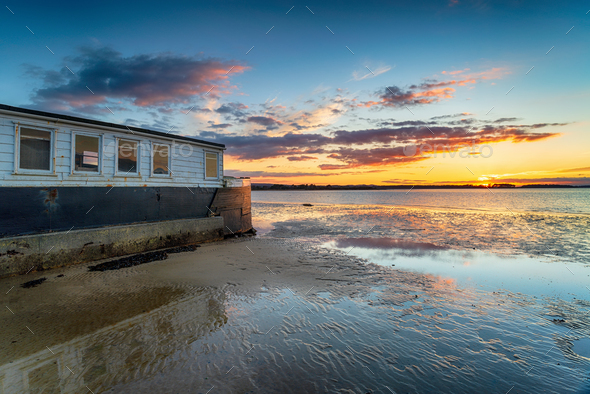Sunset over an old boat on Bramble Bush Bay at Studland in Poole Harbour - Stock Photo - Images