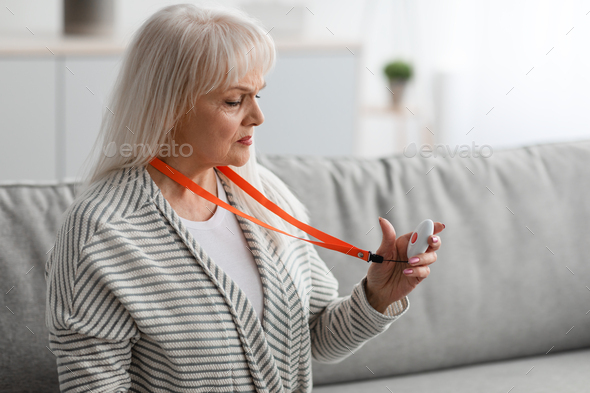 Emergency call system. Senior woman holding Alarm Button, closeup