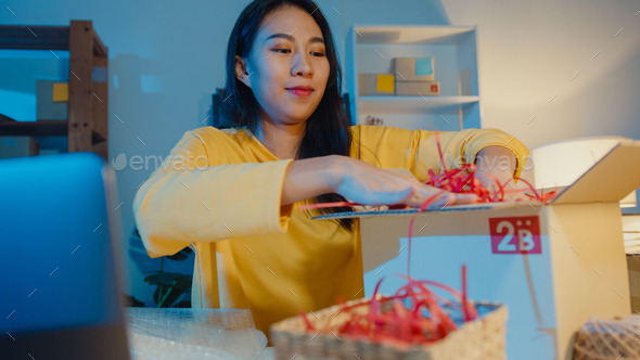 Asia woman packing box parcel use paper for support product easy damage fragile product. - Stock Photo - Images
