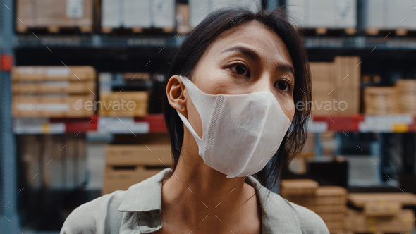 woman manager wear face mask looking for goods using digital tablet checking inventory. - Stock Photo - Images