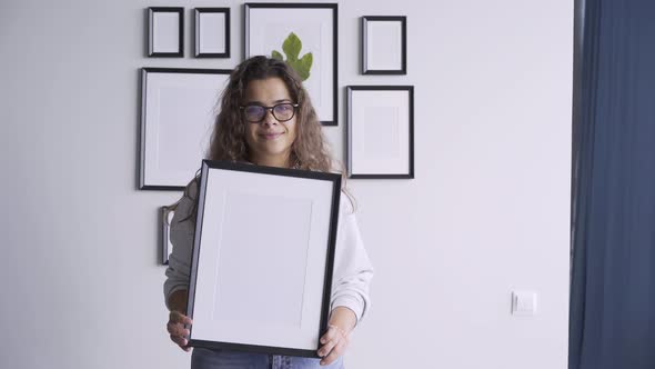 Long Haired Brunette in Glasses Holds Large Wooden Frame