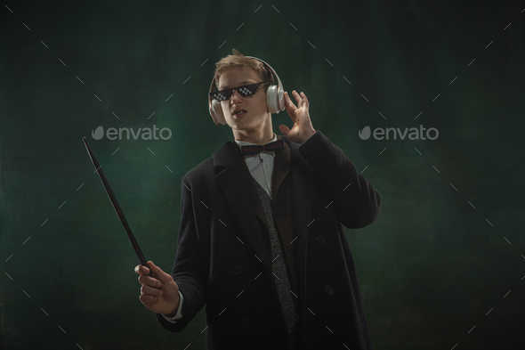Young man in art action isolated on dark green background. Retro style, comparison of eras concept - Stock Photo - Images