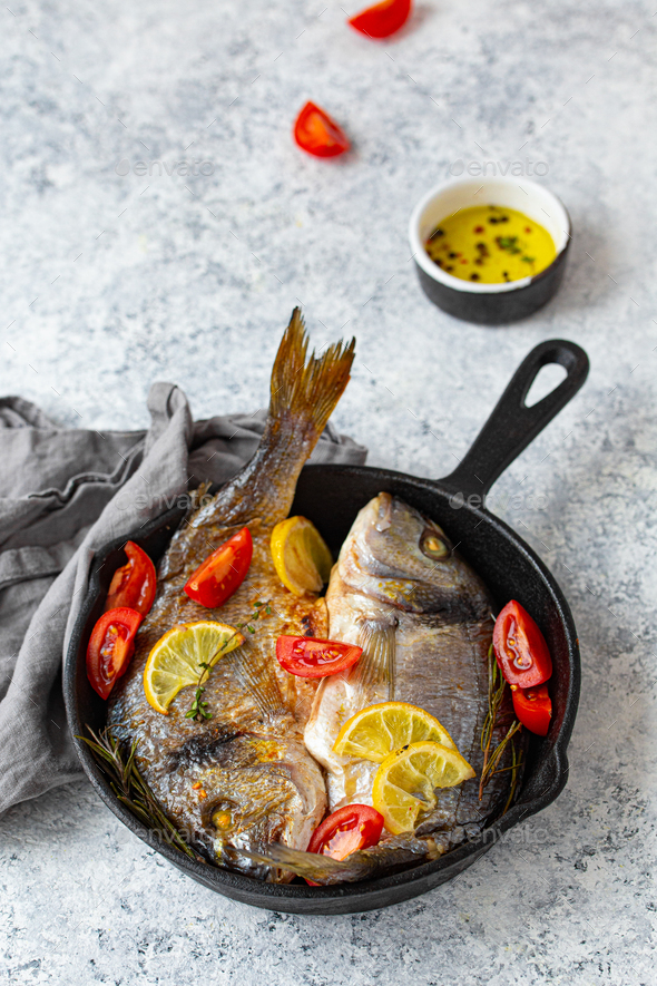 Fish Frying In Cast Iron Pan On An Outdoor Grill Stock Photo