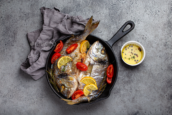 Fish Frying In Cast Iron Pan On An Outdoor Grill Stock Photo