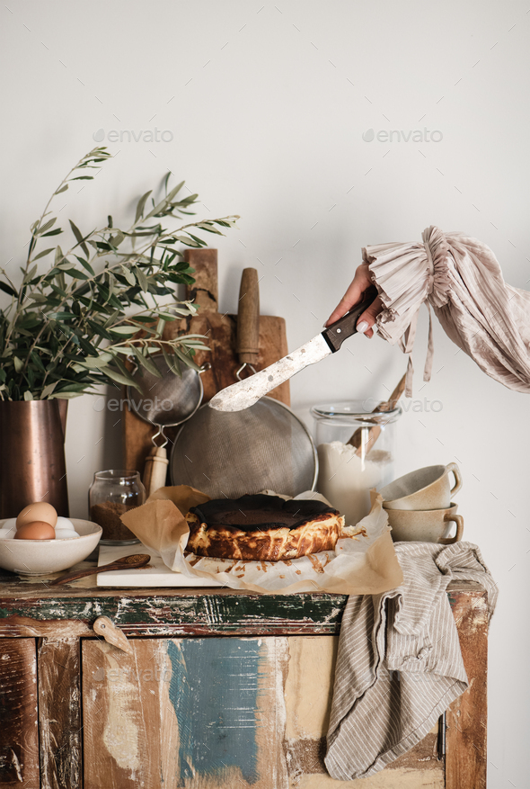 Female hands ready to cut homemade San Sebastian burnt cheesecake - Stock Photo - Images