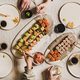 Hands of people enjoying Japanese meal with sushi at home - PhotoDune Item for Sale