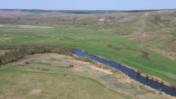 Top View of Rural Landscape with River and Green Grazing Field