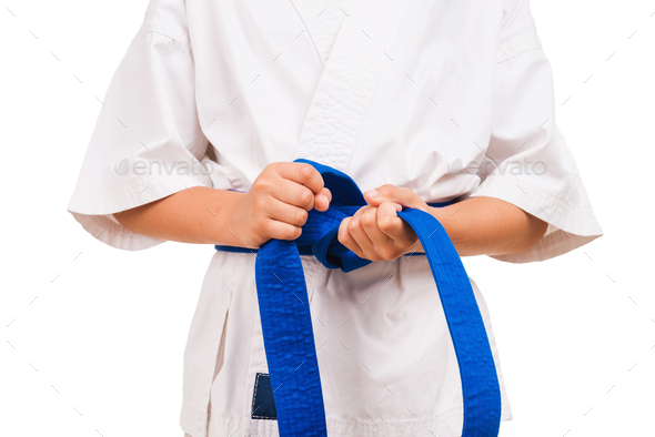 Blue belt. Little boy in kimono tying the knot to his black belt