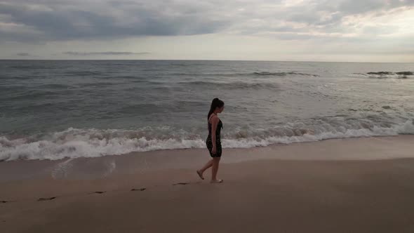 The Girl Walks on the Sand Her Feet are Washed By the Sea alt