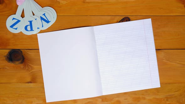 Instructor lays out a alphabet for learning spelling, notebook in an oblique line and the colored