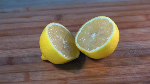 Slider Shot of Sliced Lemon Halves on a Wooden Chopping Board in the Kitchen alt