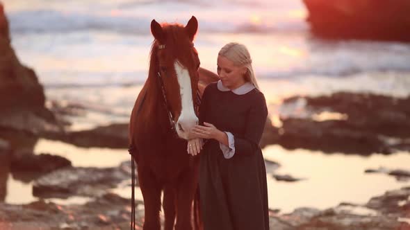 Woman with Horse on Rocky Seashore