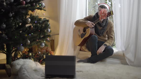 Young Man Playing Guitar Putting Musical Instrument on Floor and Holding Head in Hands alt