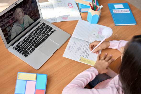 Indian kid student having online virtual class at desk at home classroom. - Stock Photo - Images