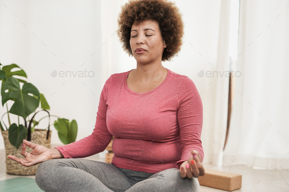 Young curvy african girl doing yoga exercise at home Stock Photo by  SabrinaBracher