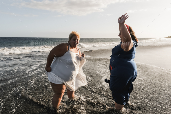 Curvy Women Dancing On The Beach Having Fun During Summer Vacation Focus On Left Woman Stock