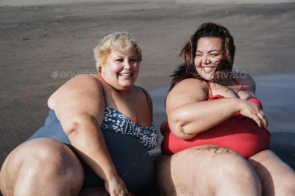 Plus Size Women Sitting On The Beach Having Fun During Summer Vacation Focus On Right Girl