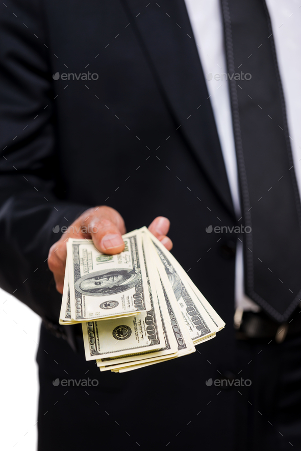 This is for you. Close-up of businessmen stretching out hand with money
