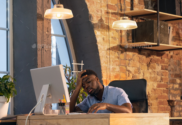African businessman, manager working in modern office using devices and gadgets - Stock Photo - Images