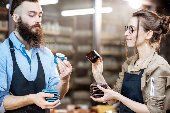 Man and woman with ceramics at the pottery Stock Photo by RossHelen