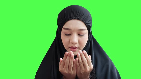 Young Muslim women praying for the blessing of Allah