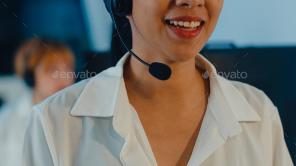 Closeup of Asia young call center team using computer and microphone headset working.