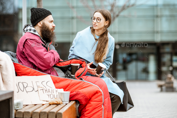 Homeless beggar with young woman listening to his story