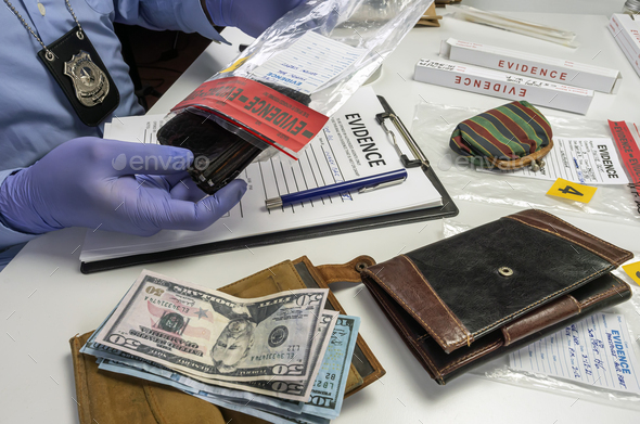 Specialised police officer takes wallet with money out of a murder evidence bag, conceptual image