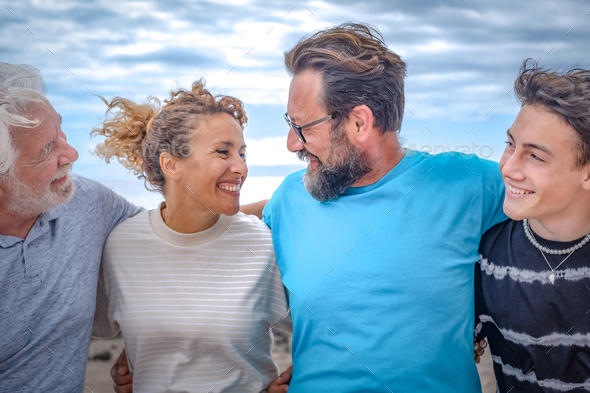Group of multi-generation family, parents, teenage son and grandfather smiling happy embracing - Stock Photo - Images