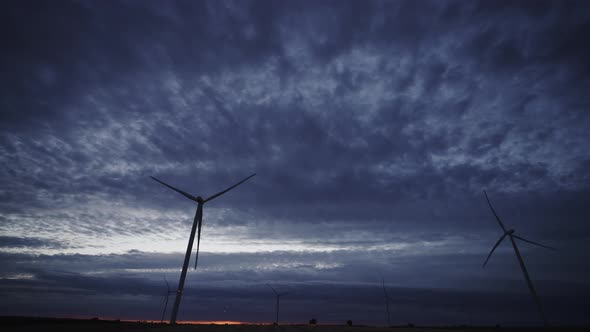 Spectacular Sunset with Clouds and Modern Wind Turbines Rotating Fast