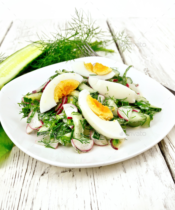 Salad with radish and egg in plate on wooden board - Stock Photo - Images