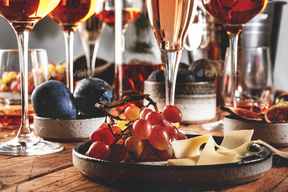 Rose wine glasses and bottles on table served for festive dinner party  Stock Photo by Olga_Kochina