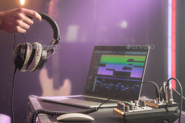 Studio headphones connected to a music mixer. Studio sound recording  concept on blurred background. Stock Photo by puhimec