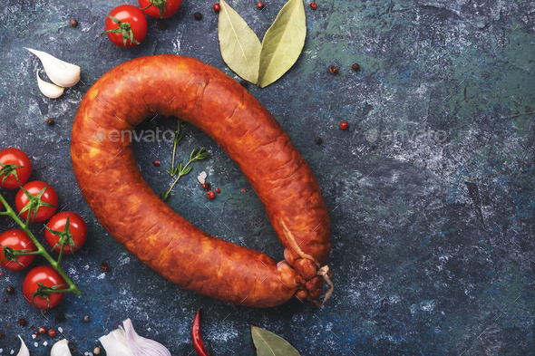 Smoked sausage circle on blue kitchen table - Stock Photo - Images