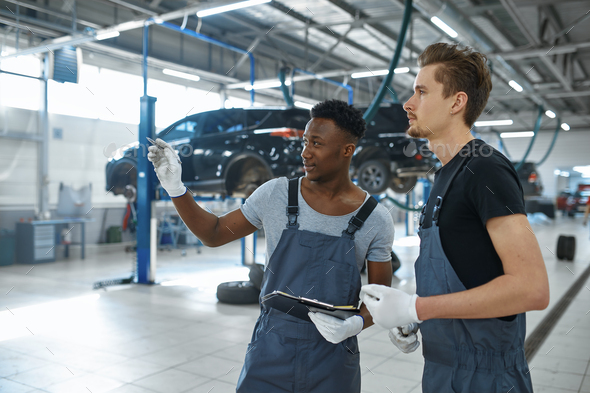 Two male mechanics talking in car service - Stock Photo - Images