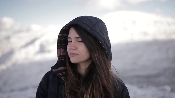 Tourist in outerwear against high ridges in wintertime alt