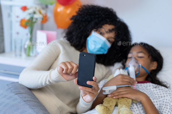 Mixed race mother in face with sick daughter on oxygen ventilator using in hospital Stock Photo by Wavebreakmedia