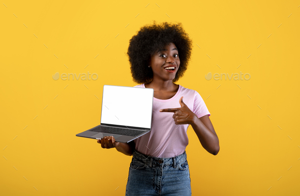 New website. Happy black lady holding laptop computer with blank screen ...