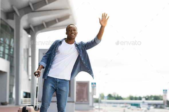 Portrait Of Happy Handsome Black Guy Catching Taxi Near Airport Terminal