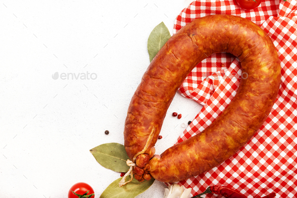 Smoked sausage circle on white kitchen table - Stock Photo - Images