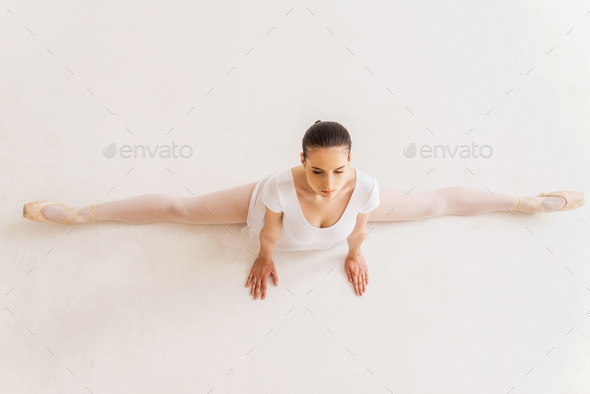 Ballerina doing splits. Top view of young ballerina in white tutu doing splits