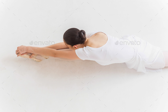 Ballerina stretching. Top view of young ballerina doing stretching exercises