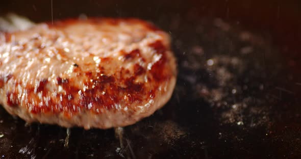 Frying the Meat Burger with a Spatula on the Pan. alt