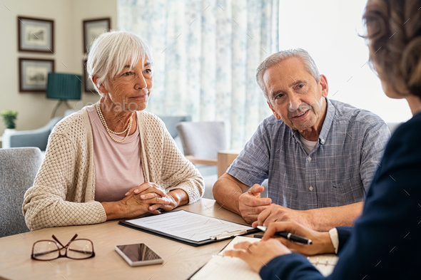 Senior couple planning their investments with financial advisor - Stock Photo - Images